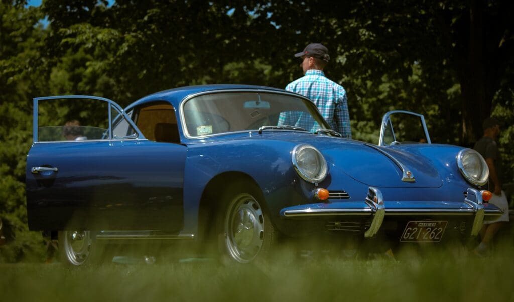 A man standing next to a blue sports car