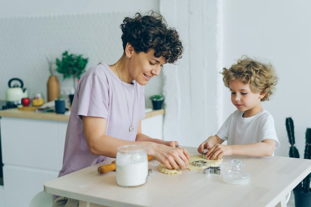 a woman and a child are making cookies