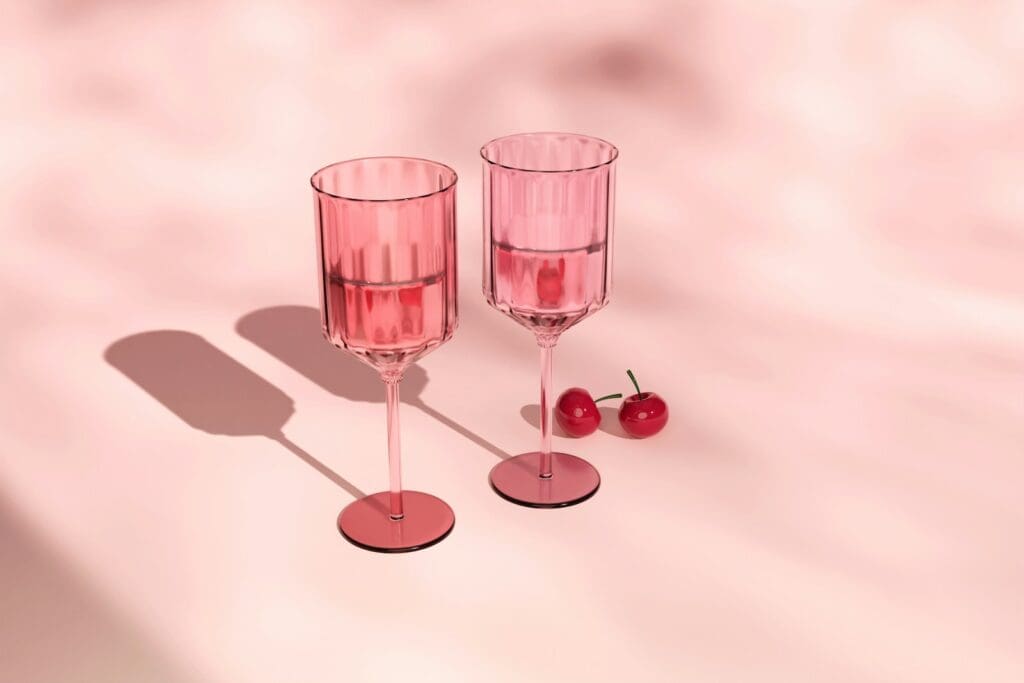 Two glasses of wine with cherries on a table