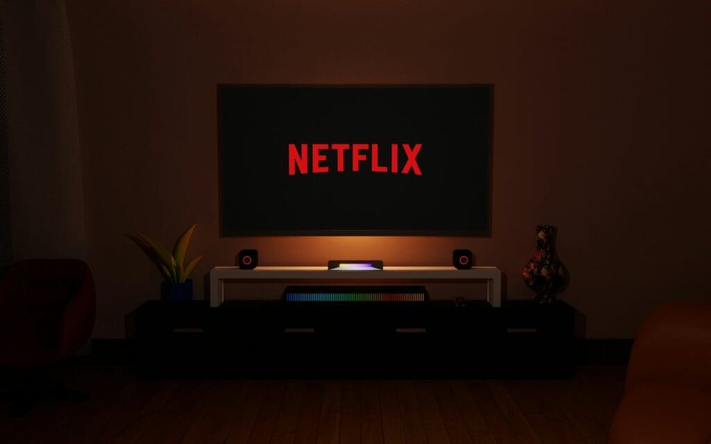 a dark room with a television and a neon netflix sign