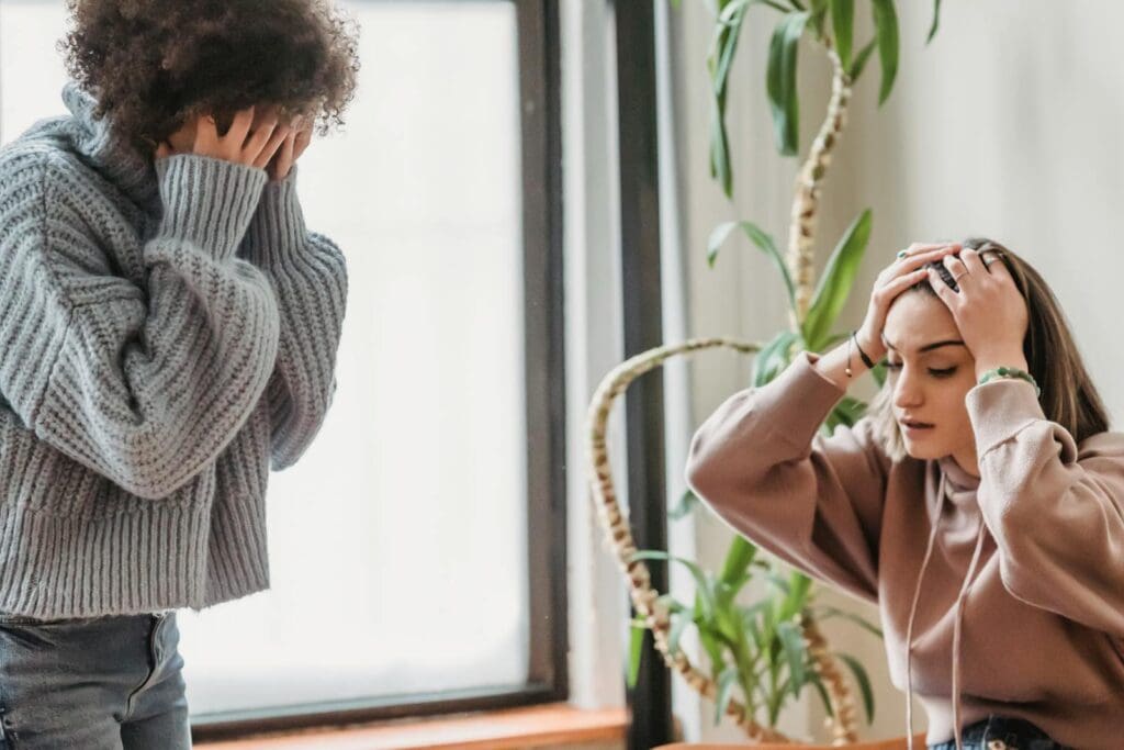 Two women expressing distress during a conflict at home, showing emotion and tension.