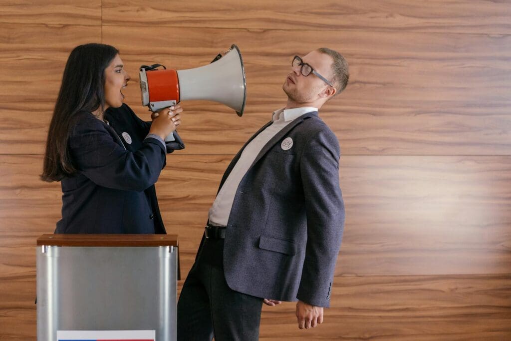 Dynamic image of two politicians arguing; one shouts into a megaphone in a heated debate.