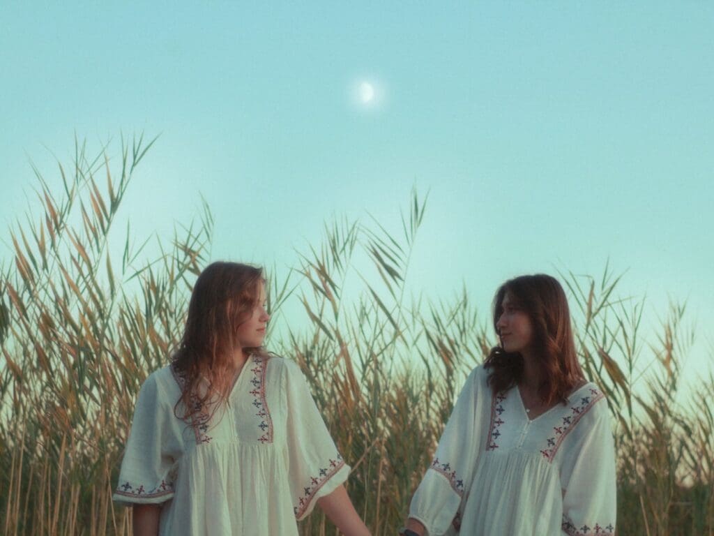 Two women are holding hands in a field