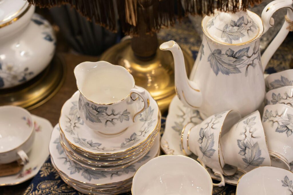 A close-up of an elegant porcelain tea set with delicate floral patterns on a table.