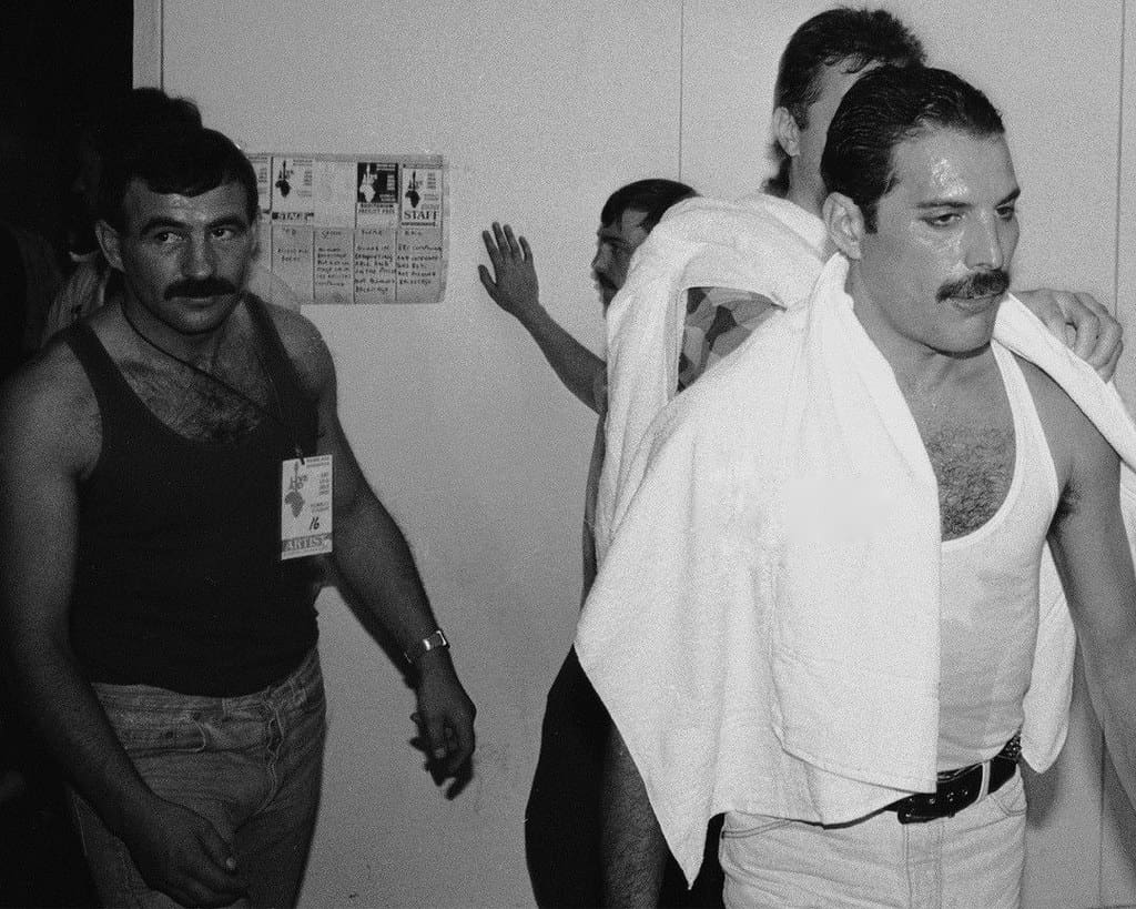 13th July 1985: Rock star Freddie Mercury of rock band Queen backstage at the Live Aid concert at Wembley. On the left is his boyfriend Jim Hutton.