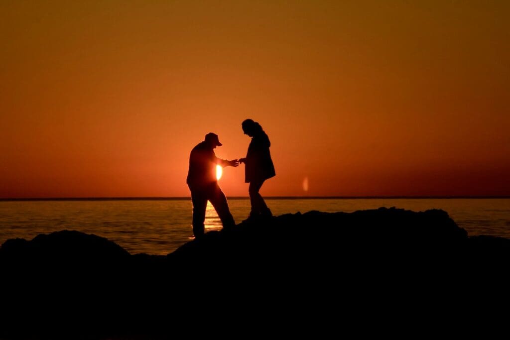 silhouette of man and woman kissing during sunset