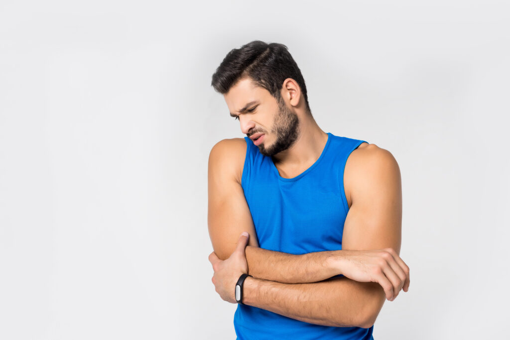 sportive young man with arm pain isolated on white