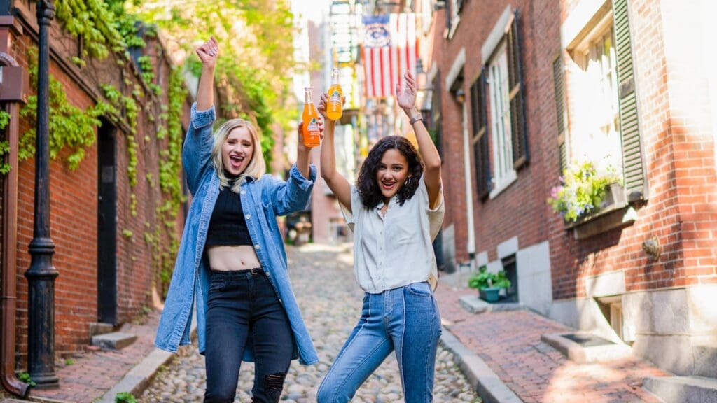 2 women standing on brown brick floor during daytime