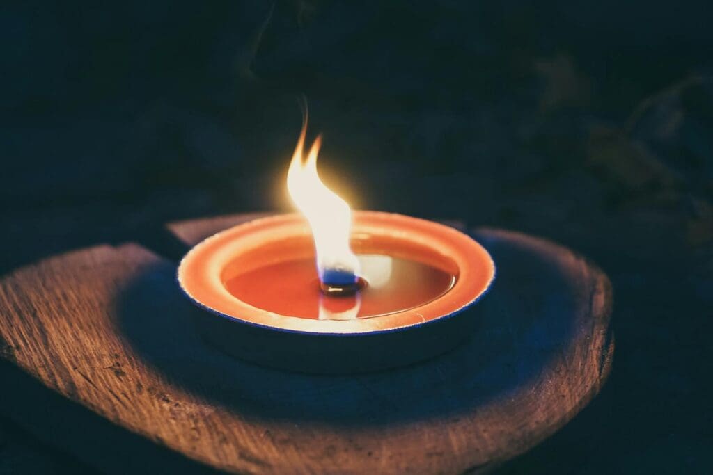A candle burns warmly on a wooden surface, creating a cozy and relaxing ambiance.