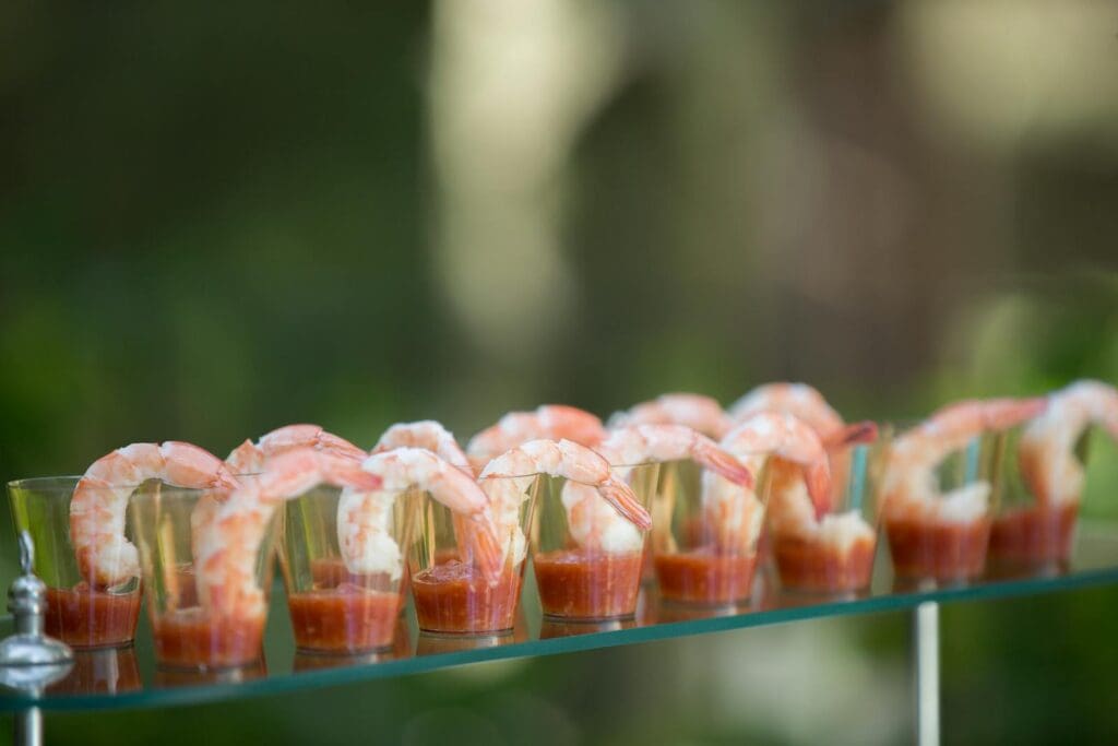 Close-up of shrimp cocktail appetizers arranged elegantly on a glass table, perfect for gourmet food presentations.