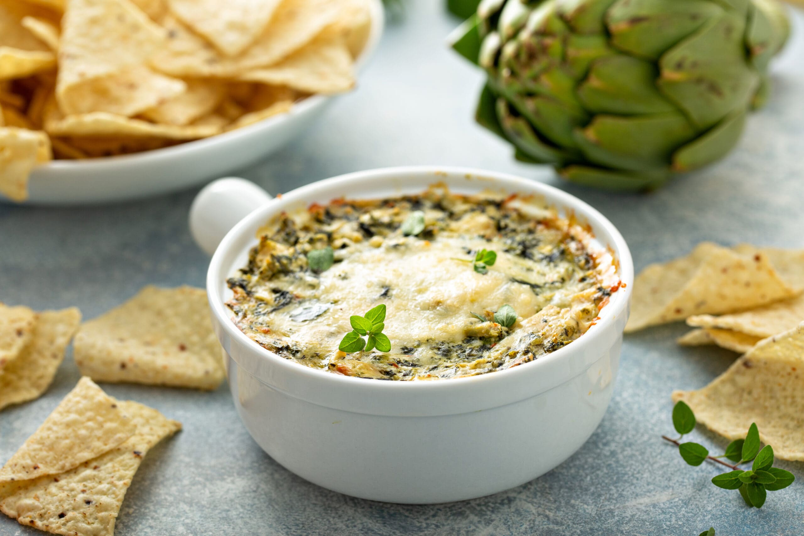 Artichoke spinach dip in a baking dish served with chips