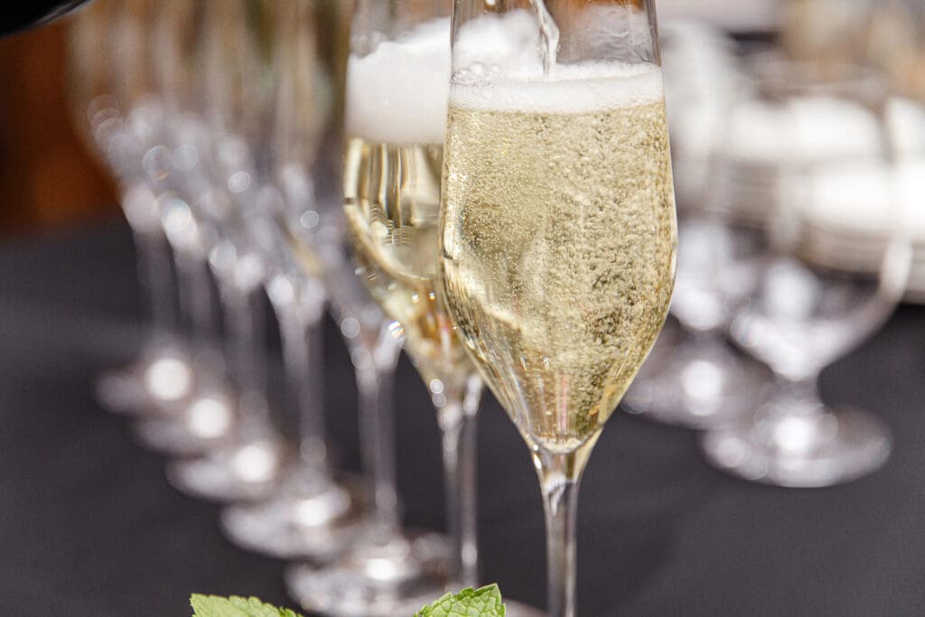 Glass of champagne in the hands of a girl at the festive table