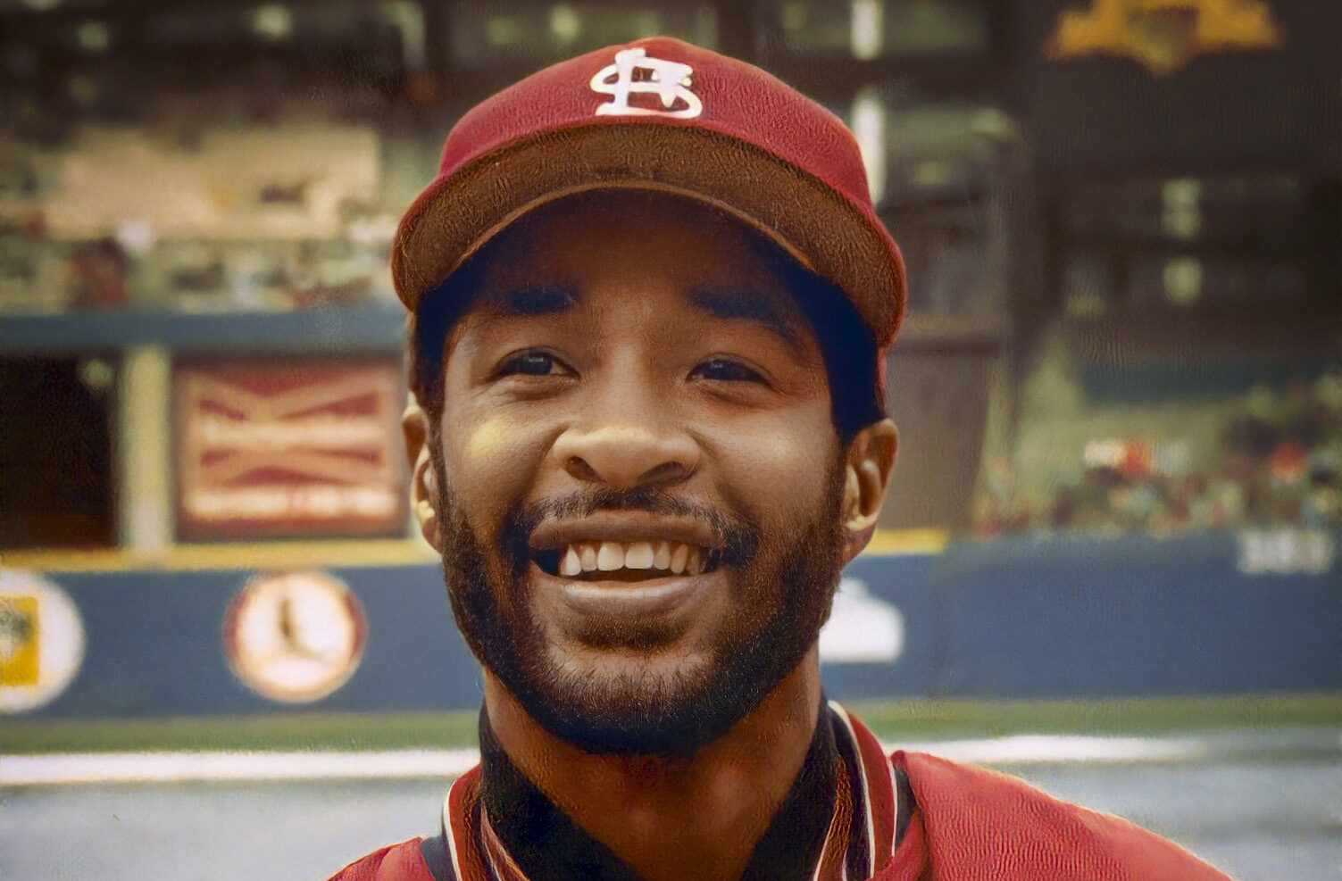 Ozzie Smith in red baseball jacket at stadium