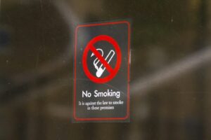 a no smoking sign on a glass door