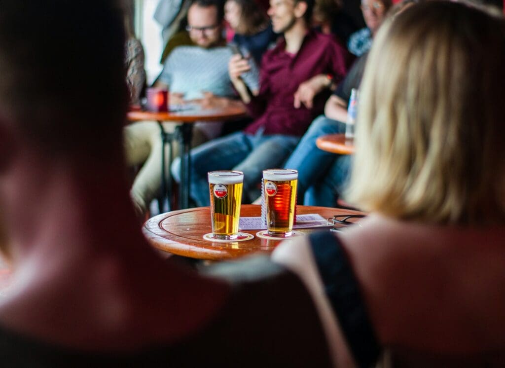 people sitting beside tables drinking beer