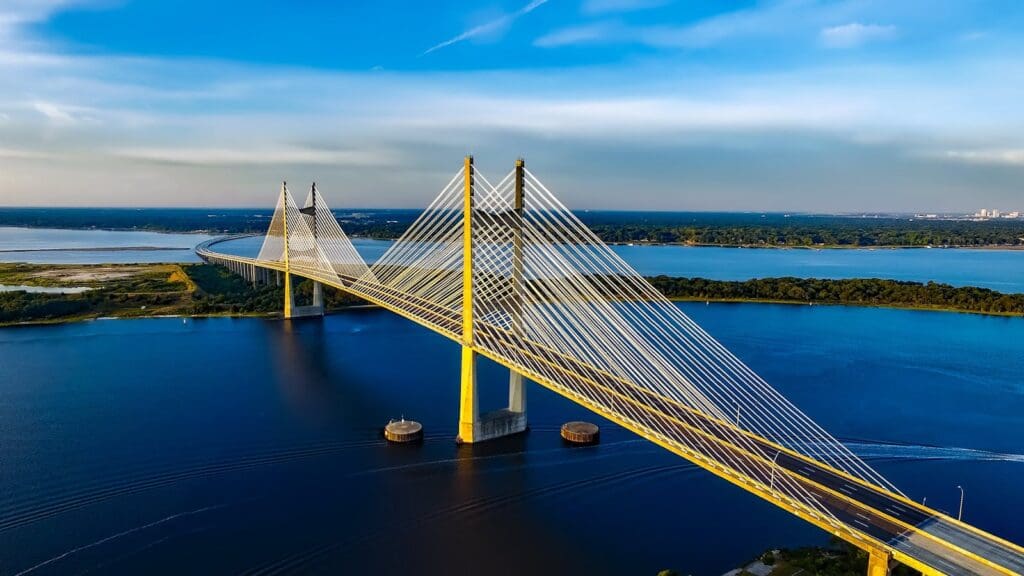 Stunning aerial shot of the Dames Point Bridge spanning over blue waters under a clear sky.