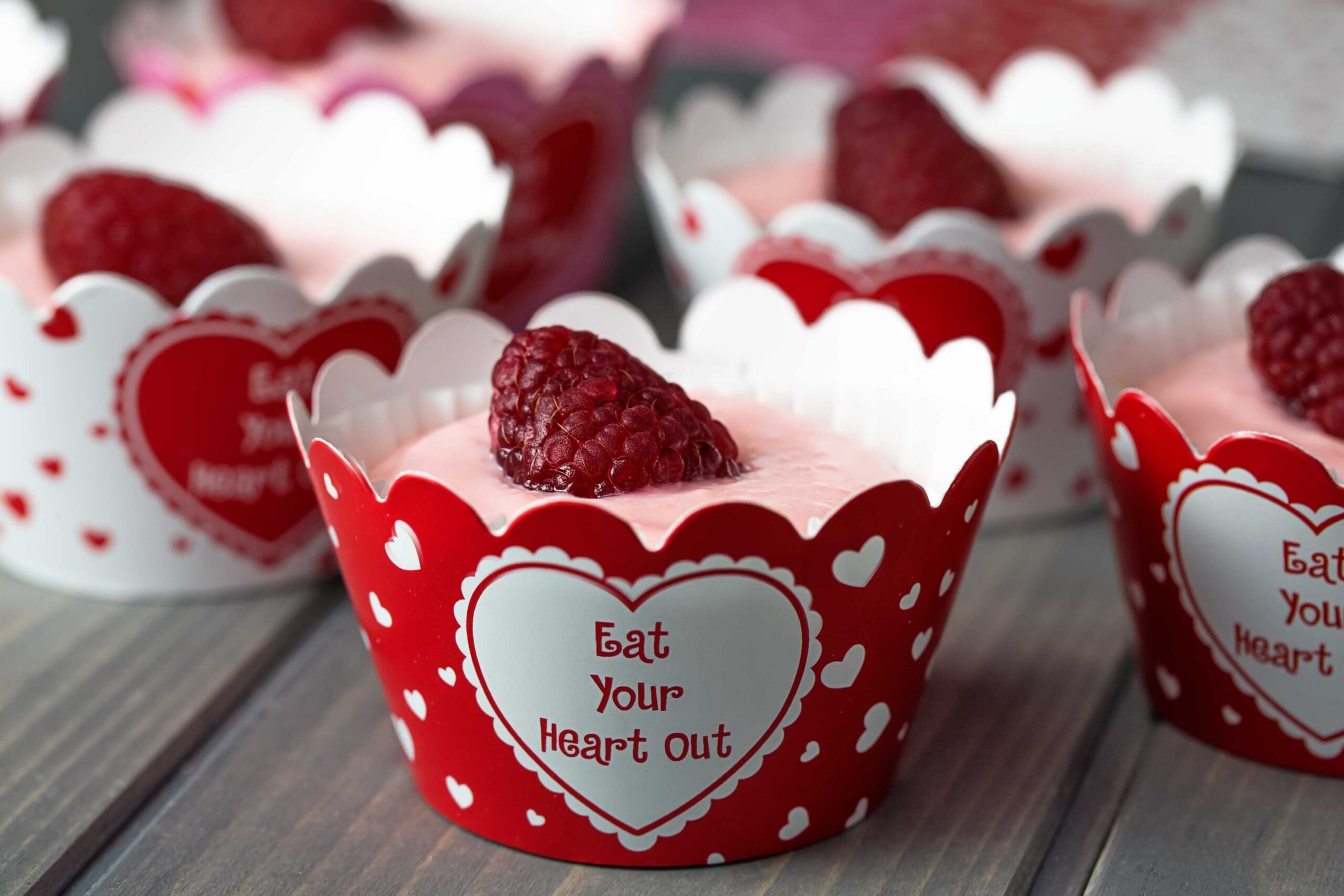 Raspberry no-bake cheesecake bites in muffin cups on a wood table (15785175113)