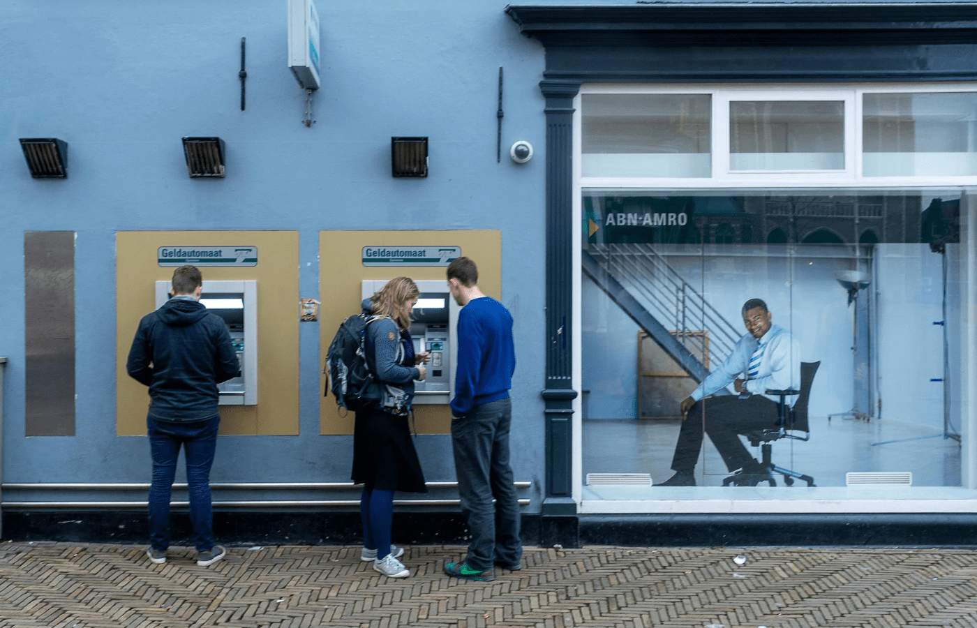 A man withdrawing cash at an outdoor ATM