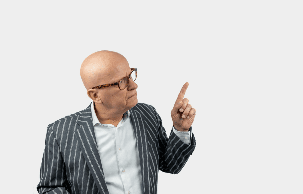 Old man pointing with a confused expression