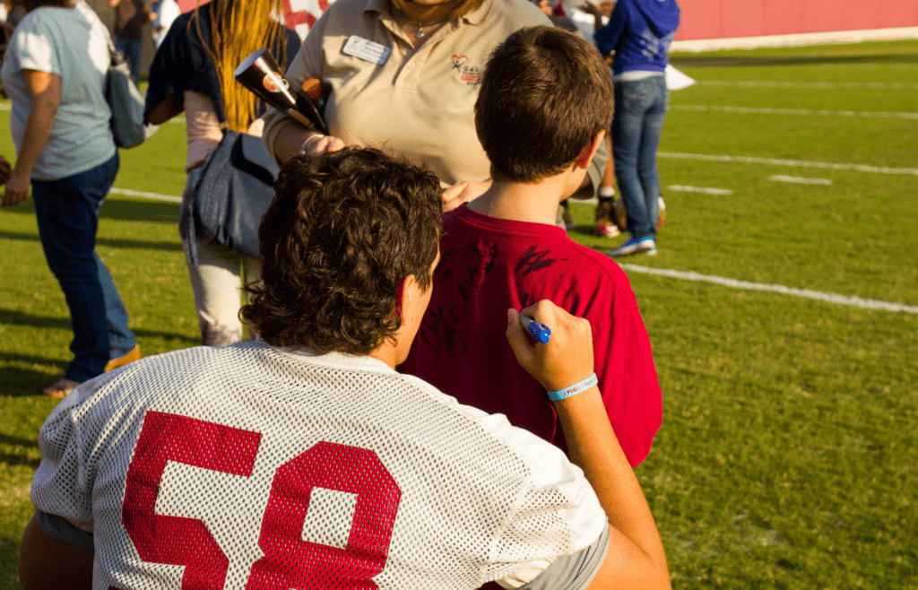 Seminoles Football player signing a fan's shirt