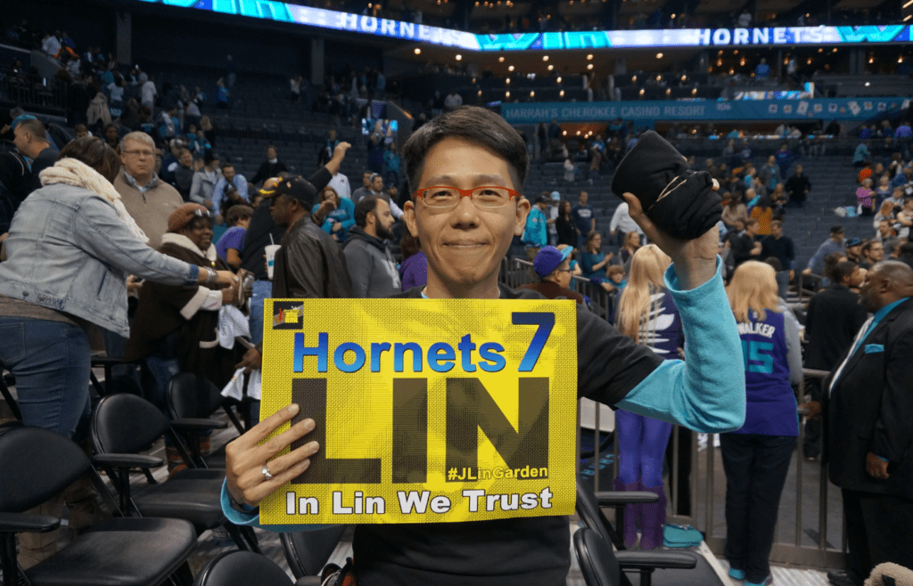 Fan holding a "Hornets 7 Lin" sign