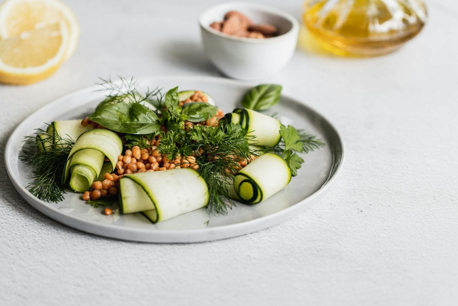 Fresh zucchini rolls and lentils with herbs on a simple plate, perfect for a light meal.