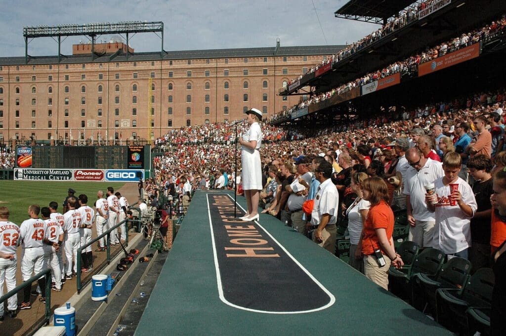 Musician 1st Class Beth E. Revell sings God Bless America, during the seventh inning stretch between the Baltimore Orioles and the Boston Red Sox at Camden Yards