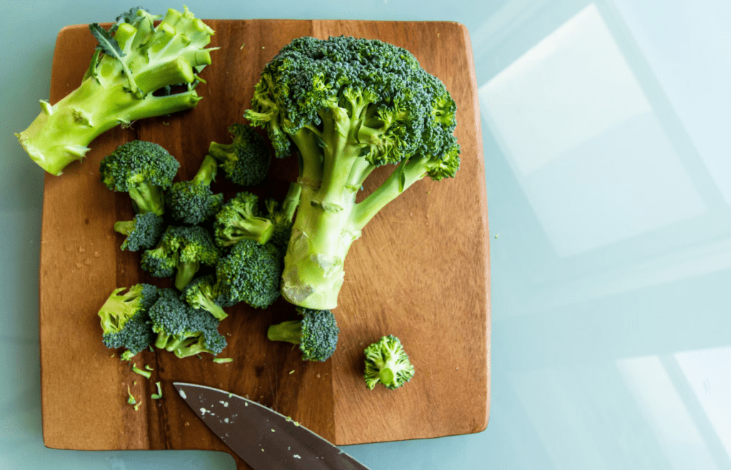 Broccoli on brown wooden chopping board
