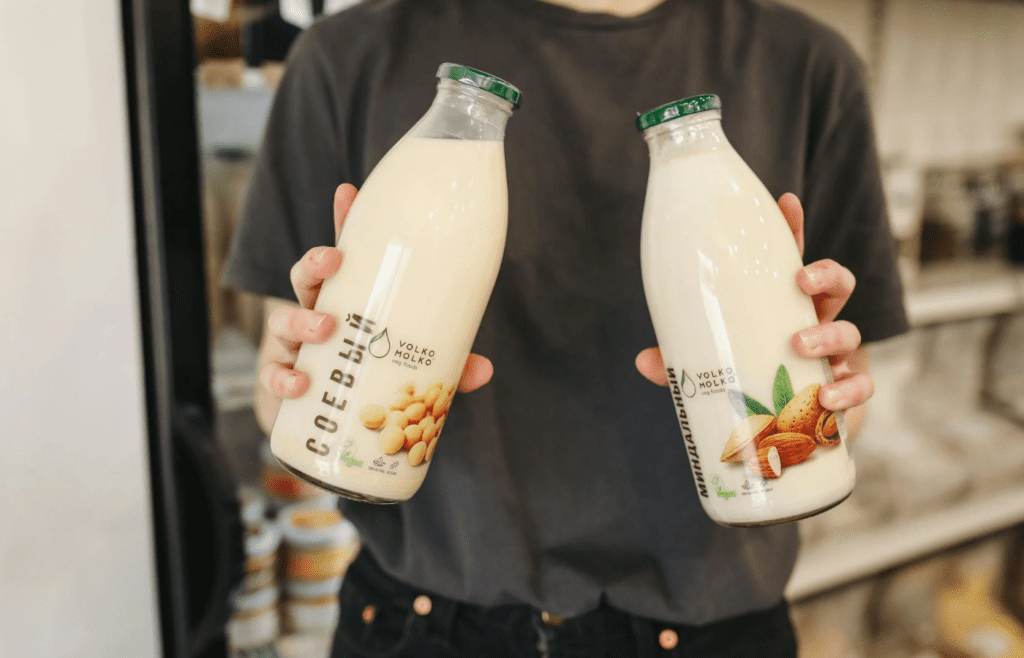 Person holding soy and almond milk bottles