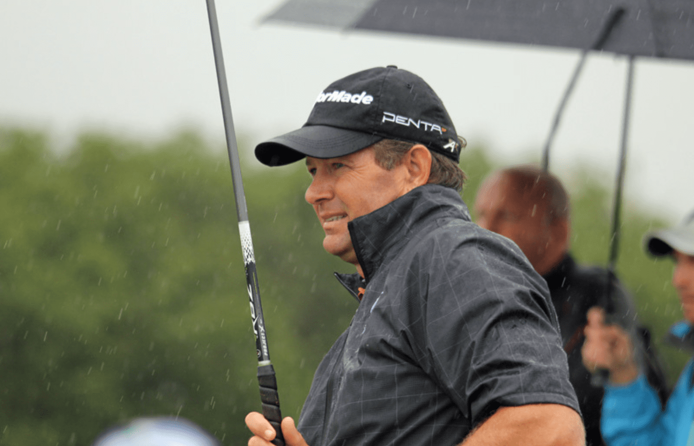 Retief Goosen Golfer smiling in the rain, holding golf