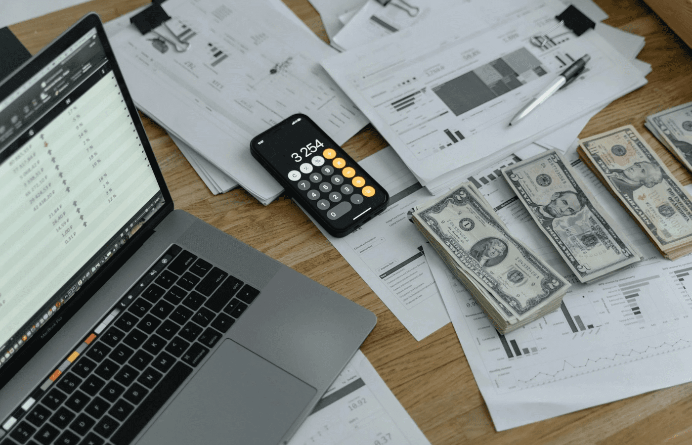 Loan documents, calculator, and banknotes on a table