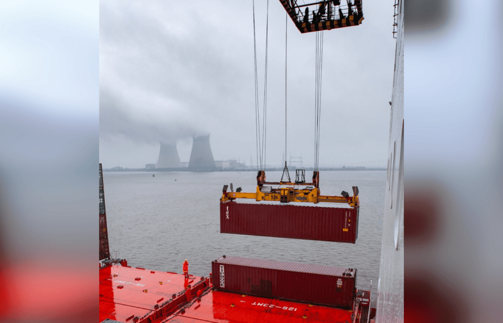 Large crane lifting shipping container from cargo ship