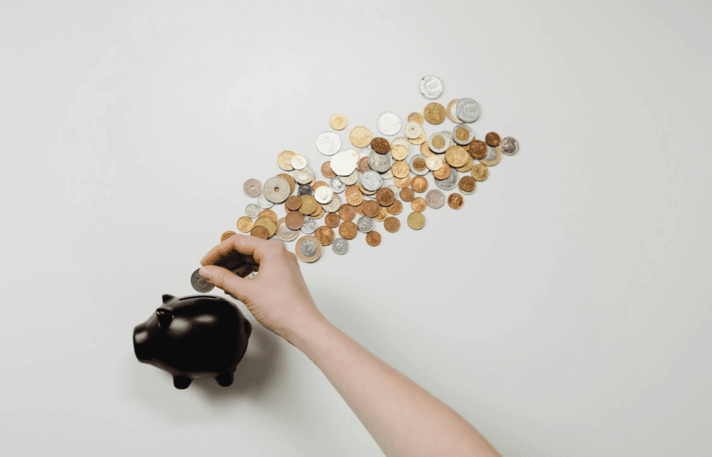 Person Putting Coin in a Piggy Bank