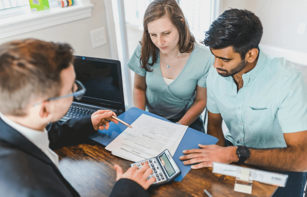 Couple discussing finances with advisor in office