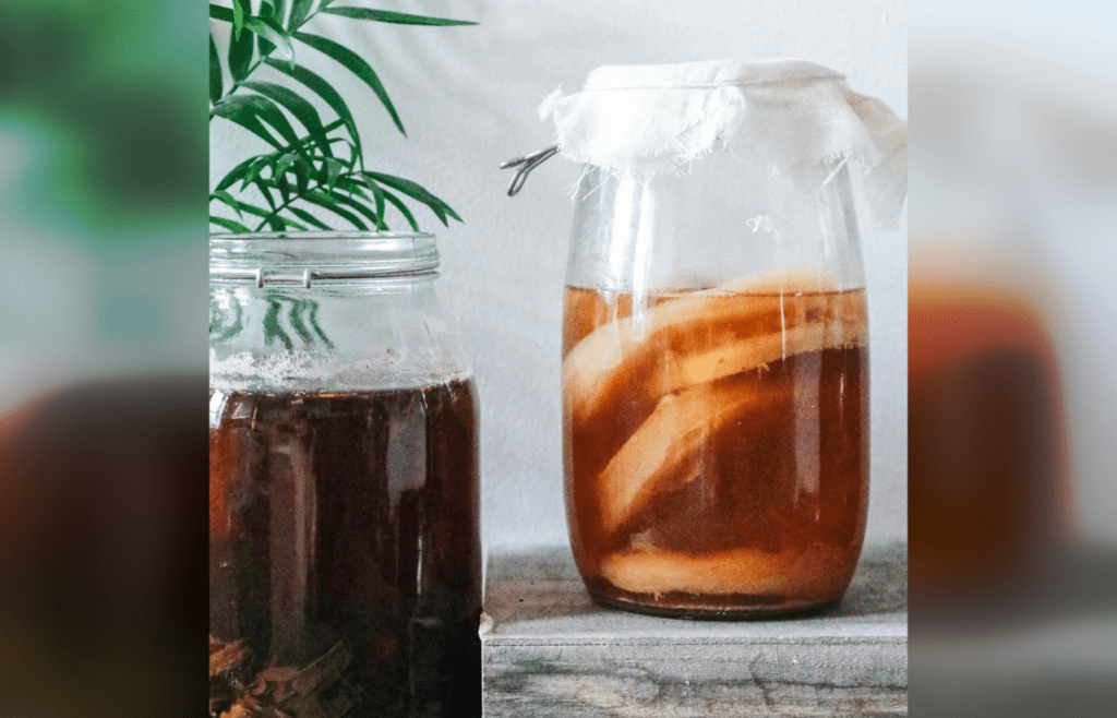 Jars with kombucha and dark herbal beverage
