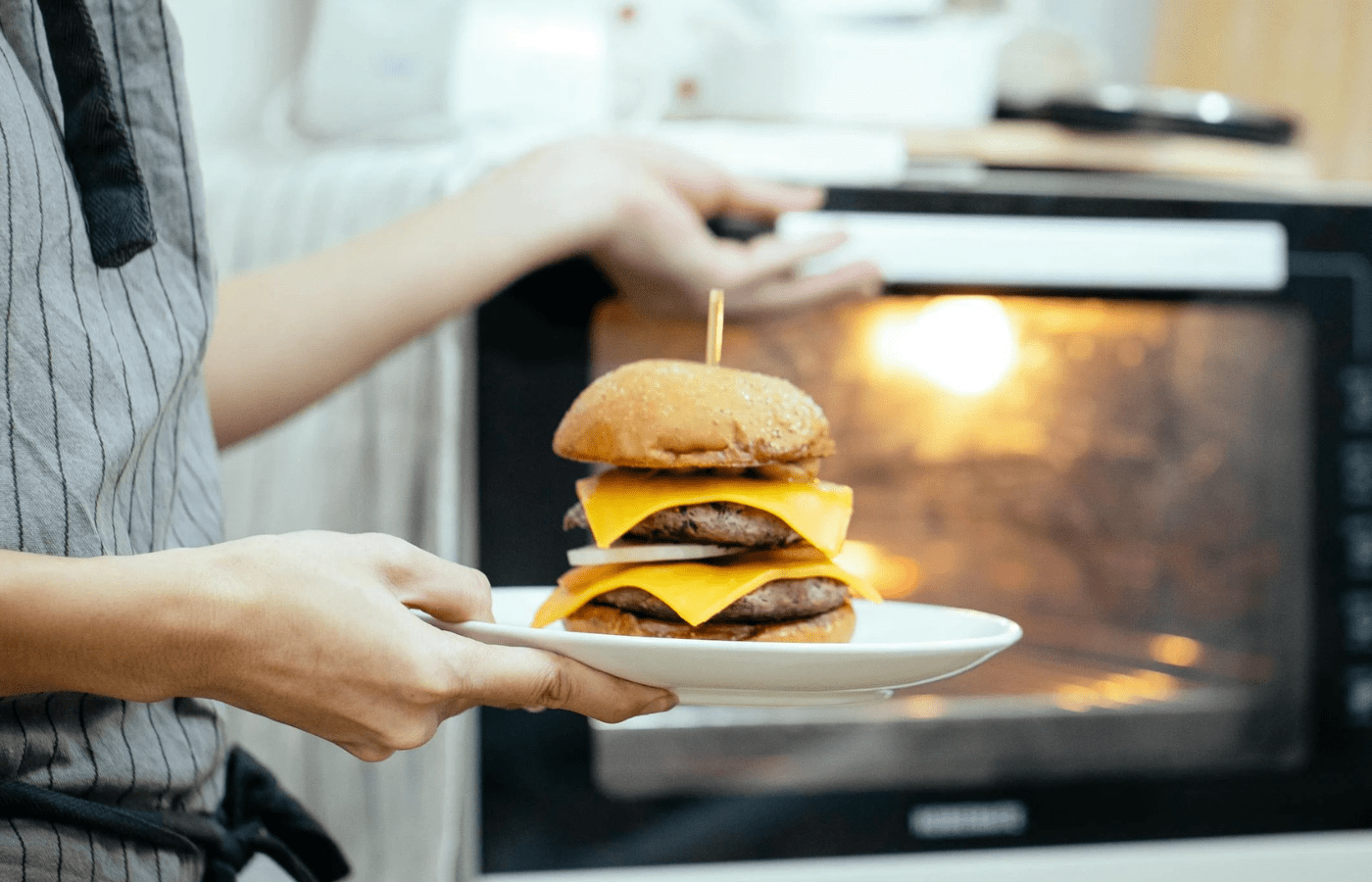 Person heating large burger in a microwave