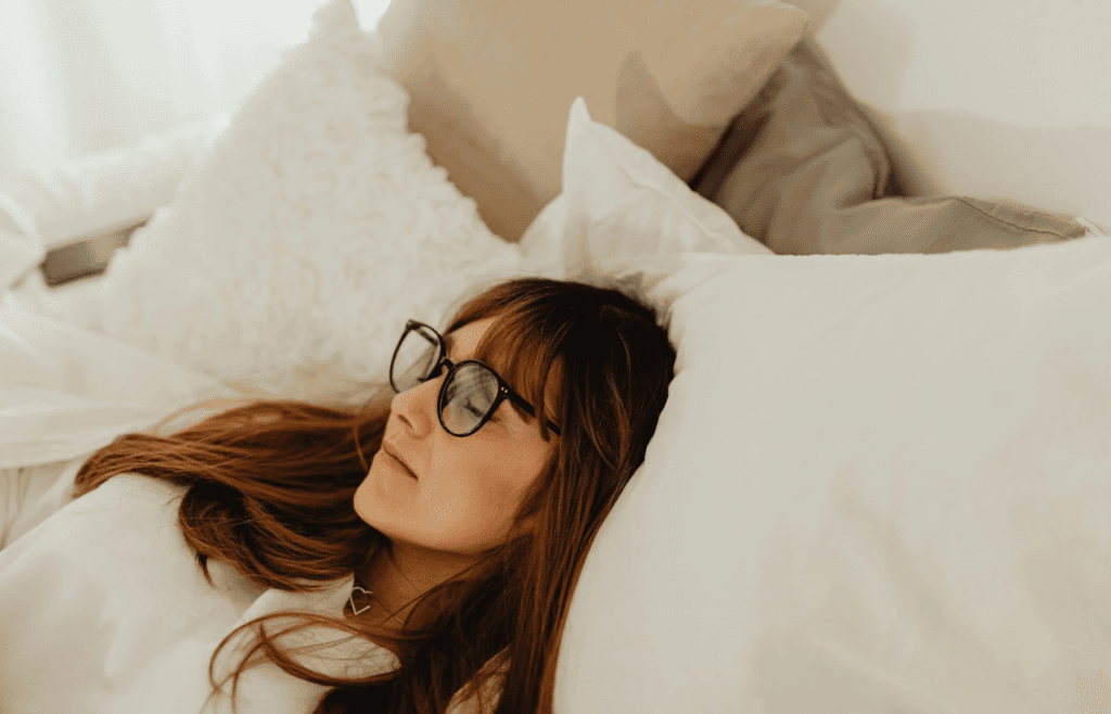 Female sleeping in bed with fluffy pillows