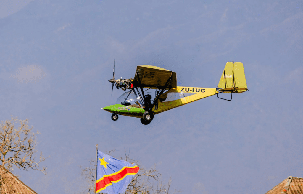 Drone-style aircraft flying above rooftops and flag