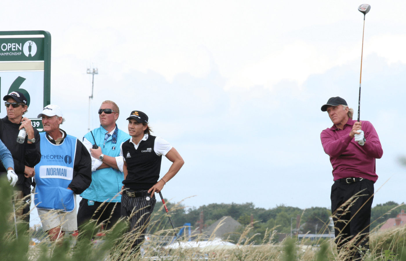 Greg Norman swinging, group watching at tournament