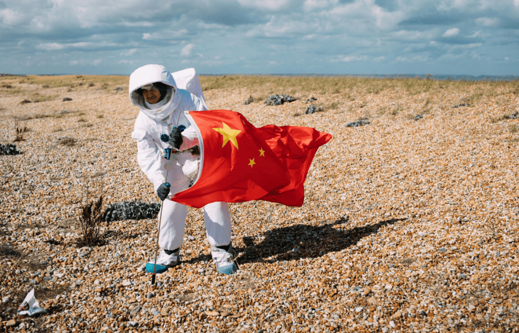 Training astronaut poses with national flag