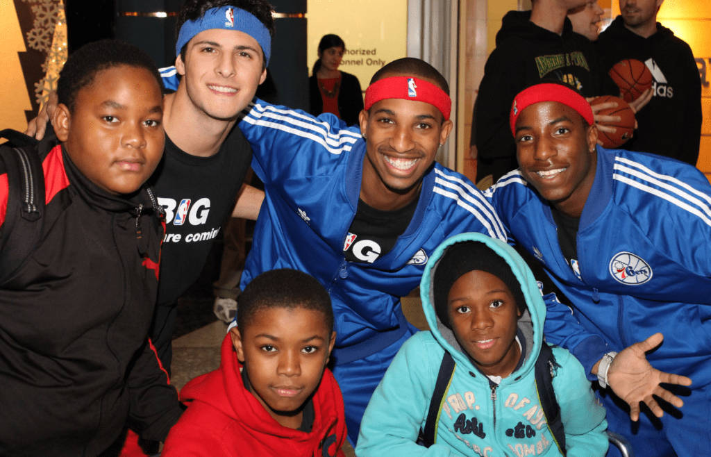 Philadelphia 76ers players posing with happy young fans