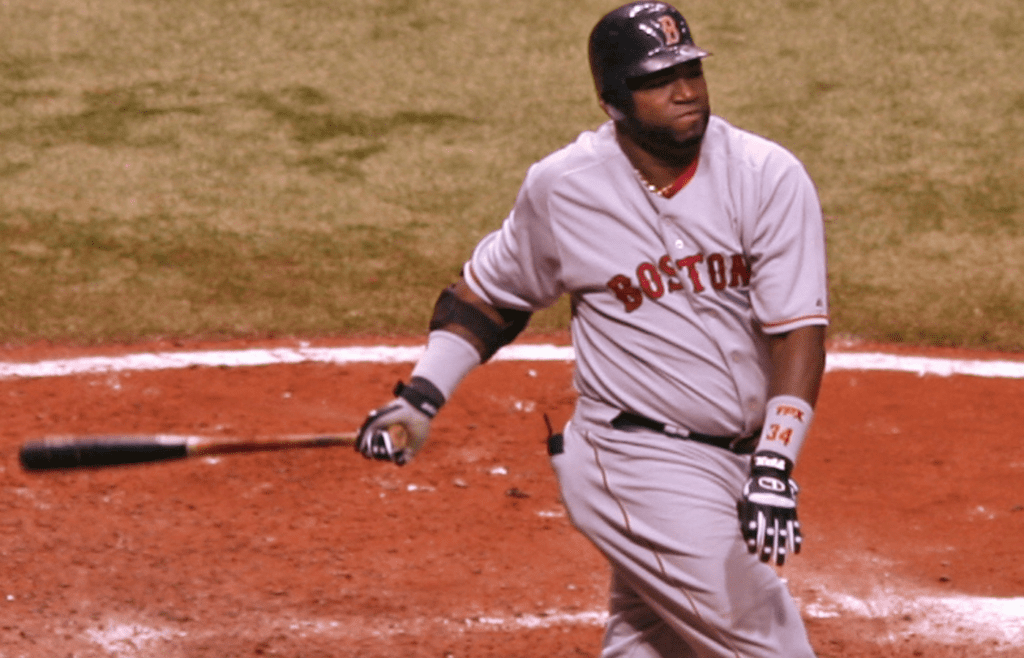 Batter from the Boston Red Sox mid-swing at the plate, wearing jersey number 34