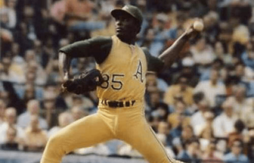 Vida Blue baseball player in mid-pitch wearing a uniform with the number 85 visible on the jersey
