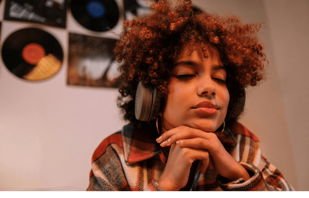 A person with headphones on, eyes closed