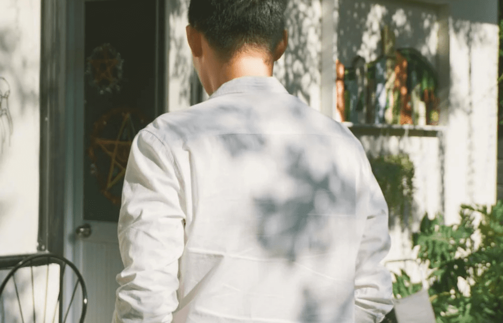 A person gazing out a window at trees or plants