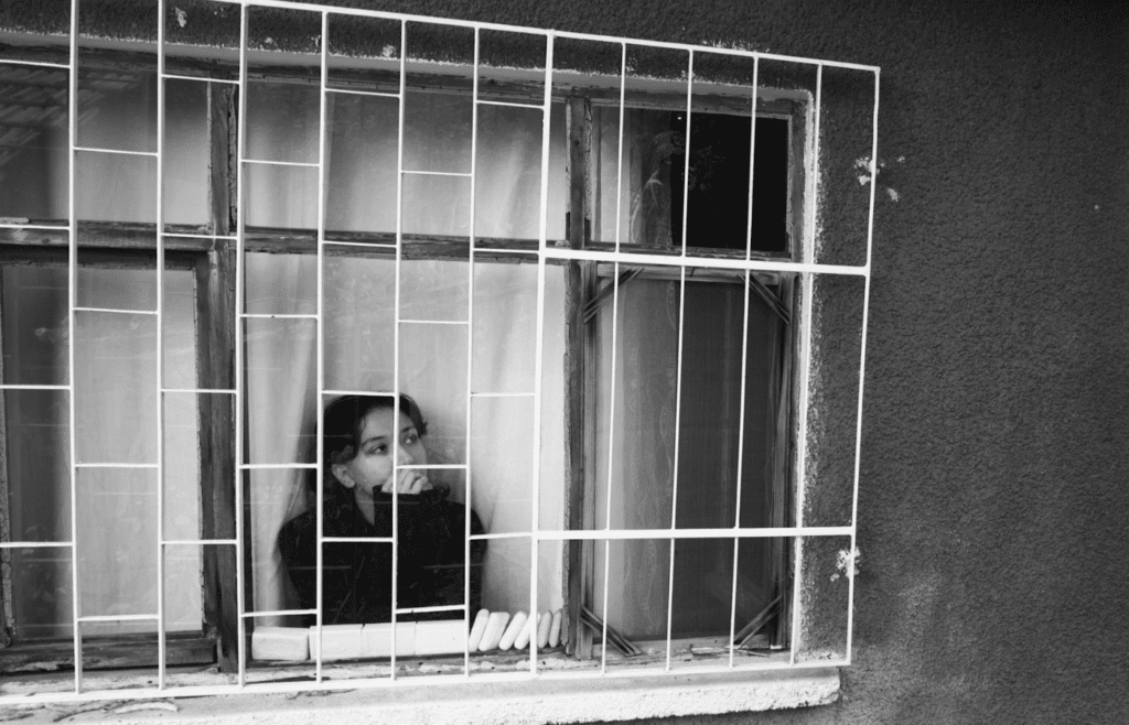 A person staring blankly out a window
