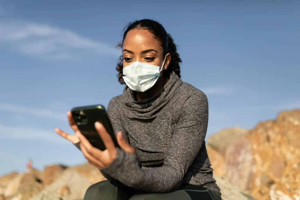 Woman wearing face mask using health app