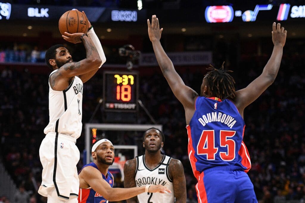 Jan 25, 2020; Detroit, Michigan, USA; Brooklyn Nets guard Kyrie Irving (11) shoots against Detroit Pistons forward Sekou Doumbouya (45) during the third quarter at Little Caesars Arena. Mandatory Credit: Tim Fuller-USA TODAY Sports