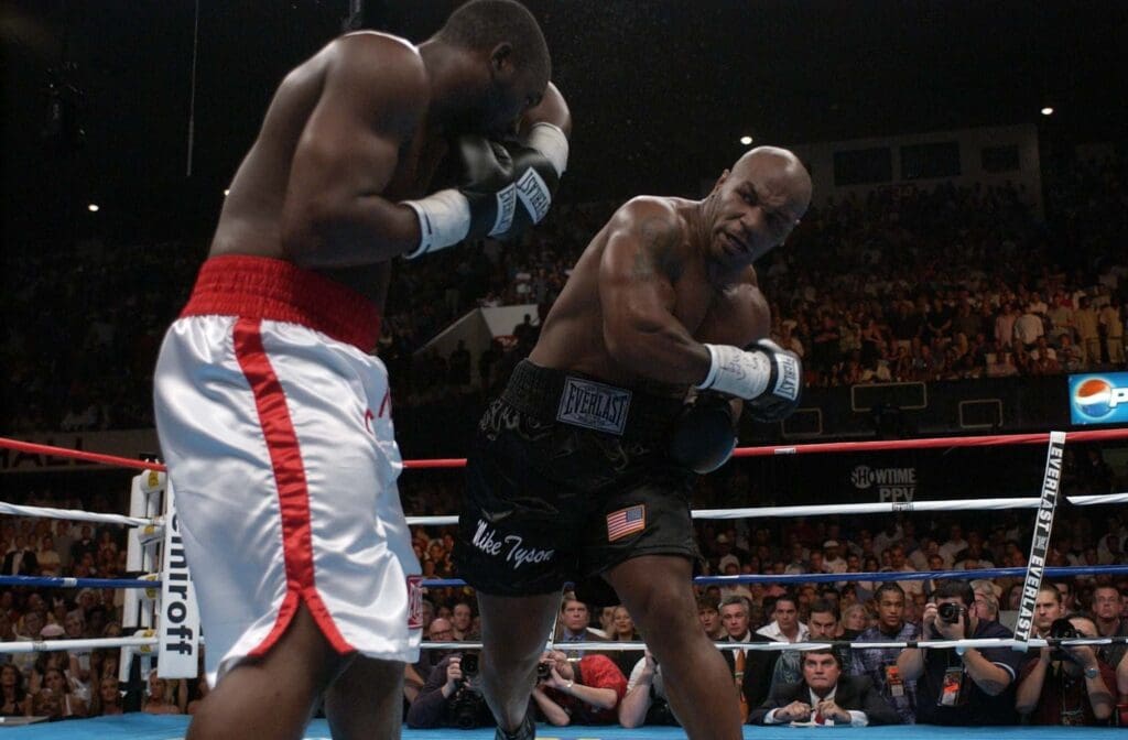 Mike Tyson delivers a shot to Danny Williams, but the 9-1 underdog scored a stunning upset at Freedom Hall in Louisville, July 30, 2004.
