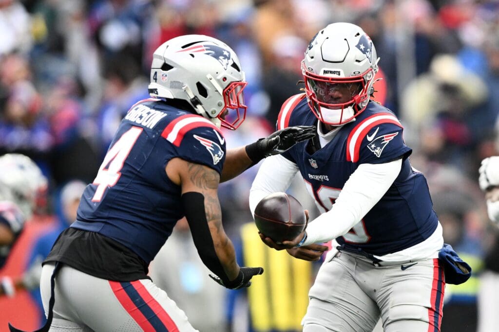 Jan 5, 2025; Foxborough, Massachusetts, USA; New England Patriots quarterback Joe Milton III (19) hands the ball off to running back Antonio Gibson (4) during the second half of a game against the Buffalo Bills. at Gillette Stadium. Mandatory Credit: Brian Fluharty-Imagn Images